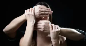 alt="le mani di un uomo coprono il viso della donna"