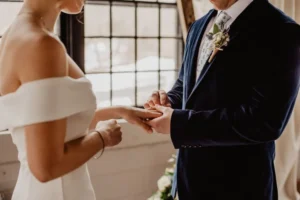 alt="lo sposo mette l'anello alla sposa"