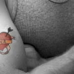 alt="cuore rosso tatuato su un braccio muscoloso di uomo"