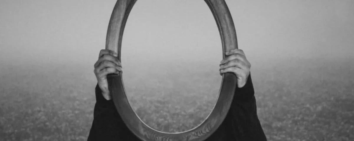 alt="donna che regge uno specchio"