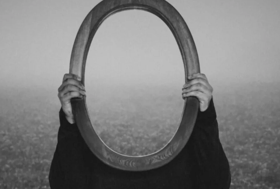 alt="donna che regge uno specchio"